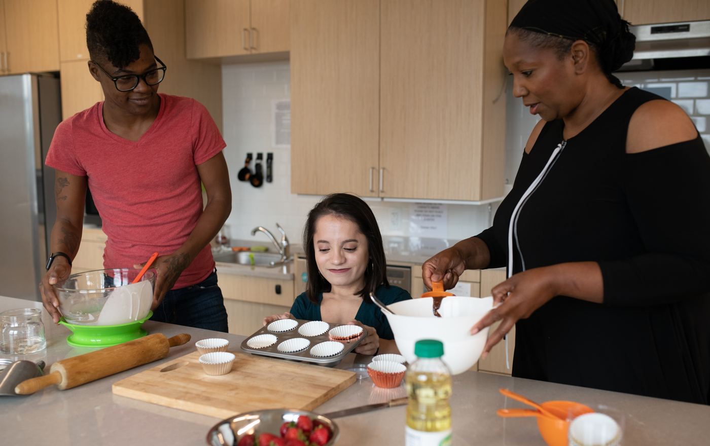 Three disabled adults baking muffins together in a home kitchen